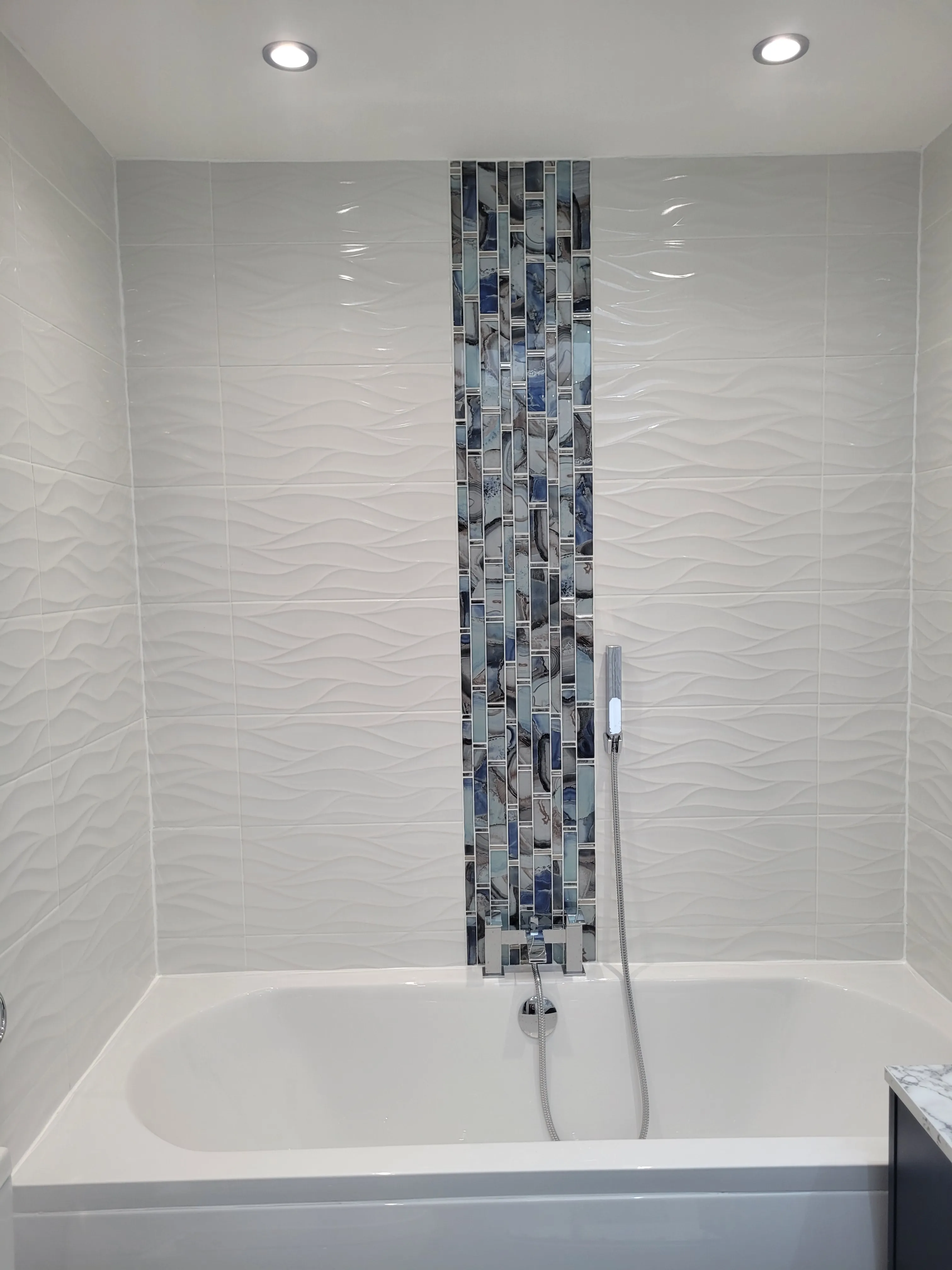 A bathroom with a bathtub and a shower head.