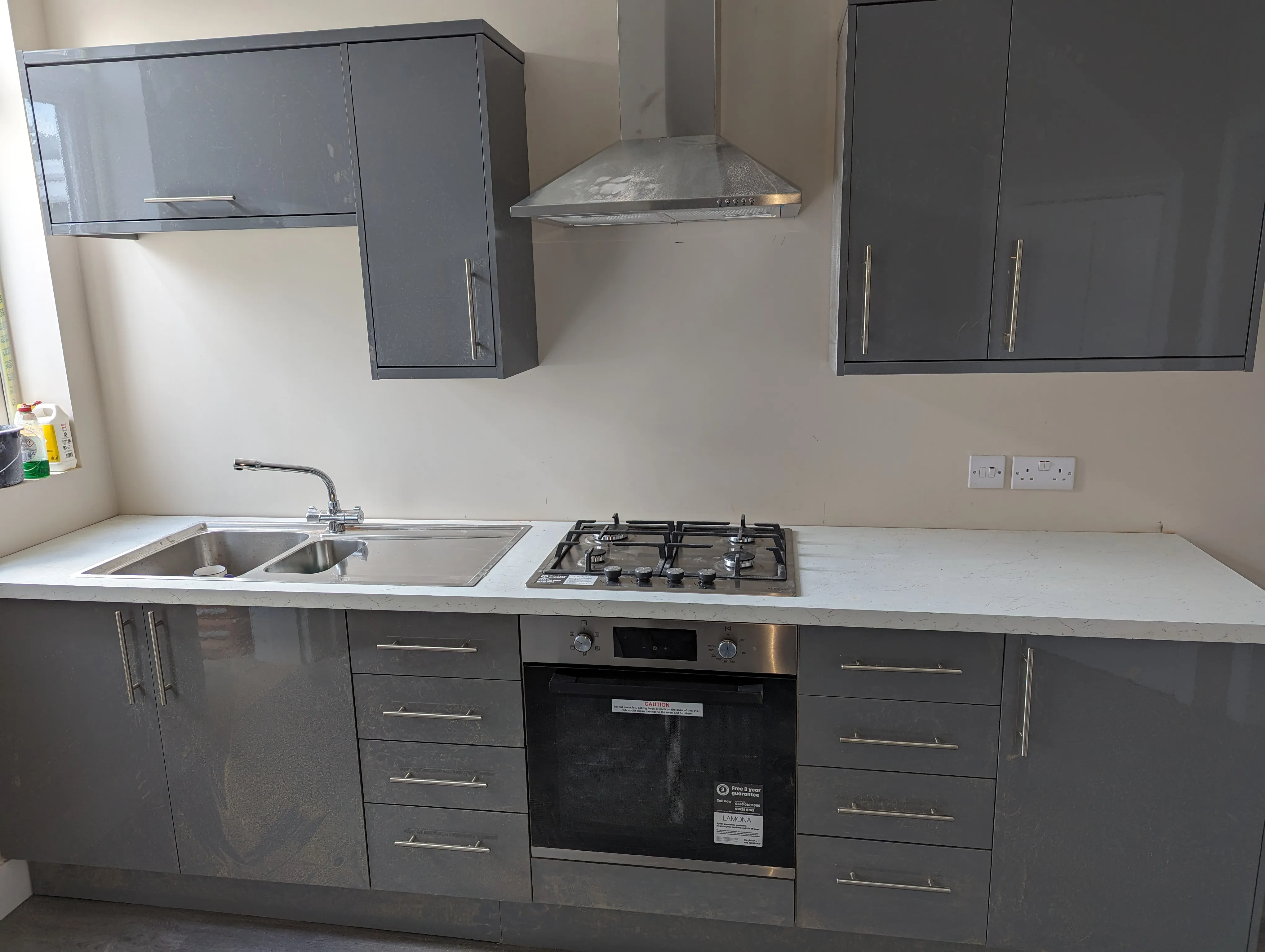 A kitchen with a stove top oven and a sink.