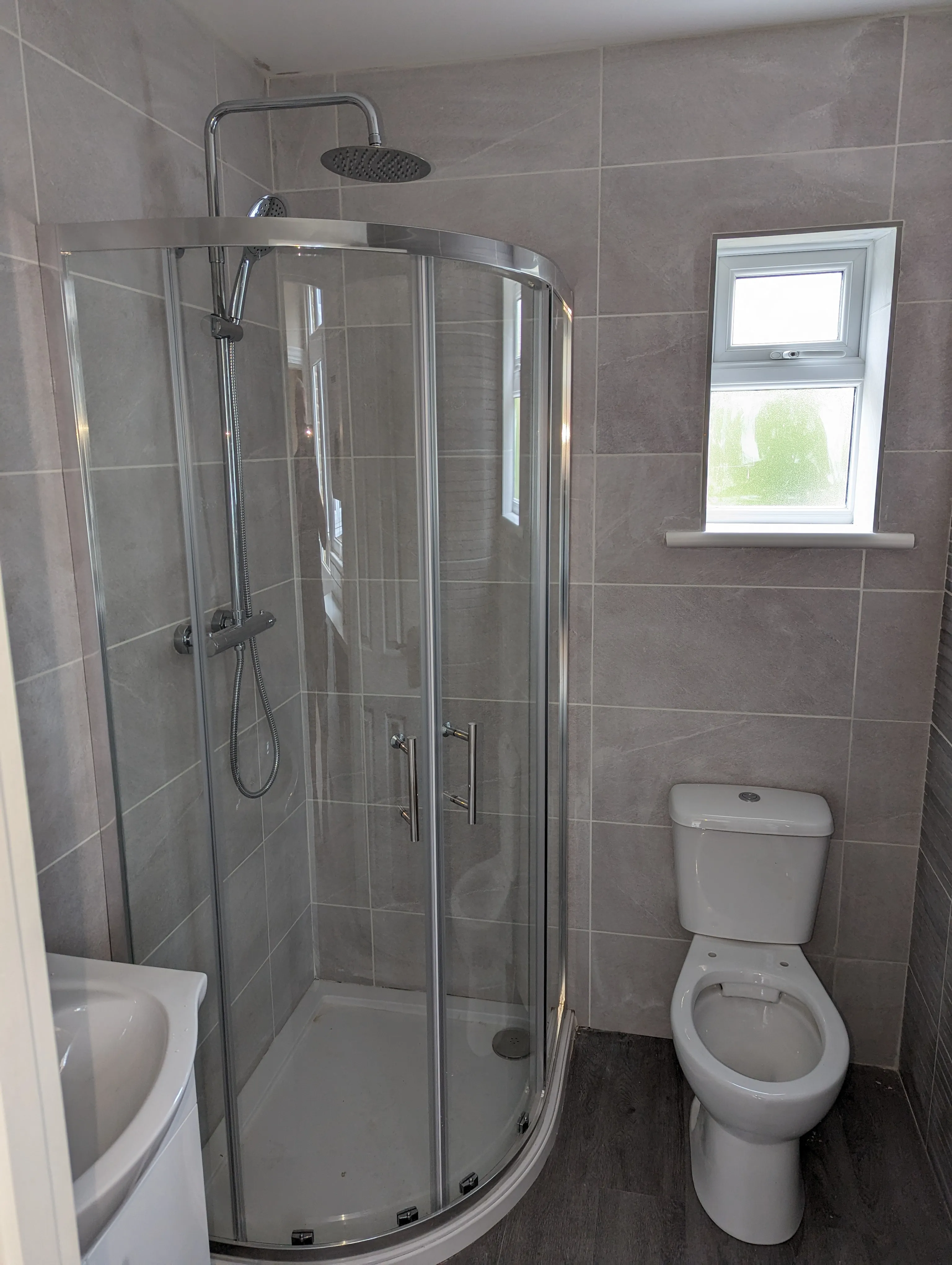 A white toilet sitting next to a walk in shower.