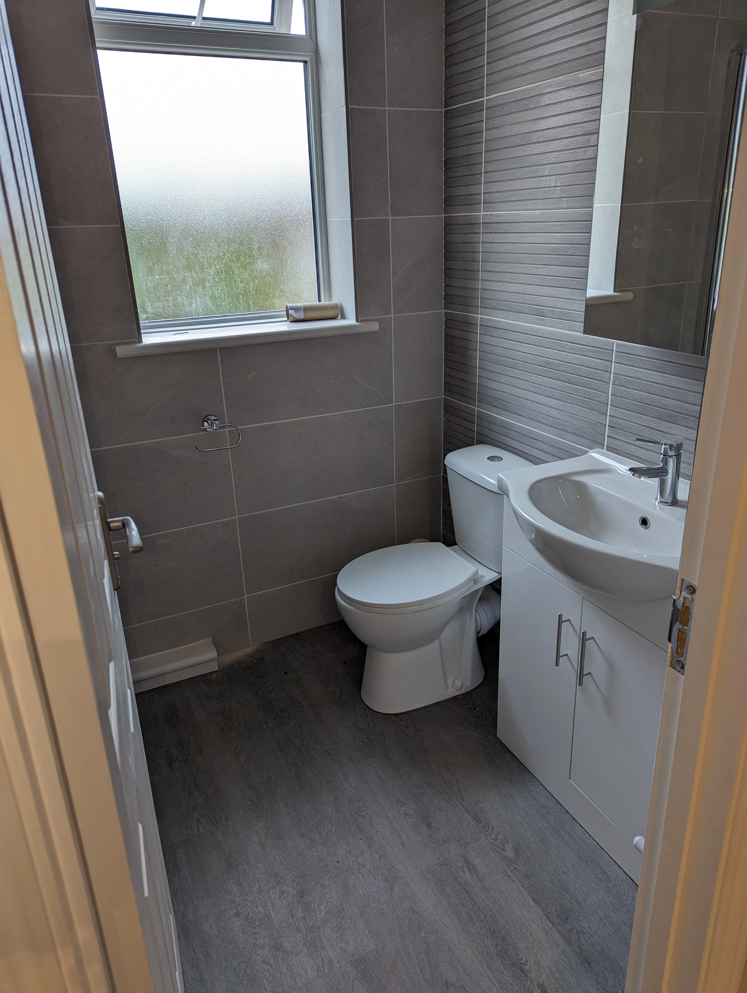 A white toilet sitting next to a bathroom sink.