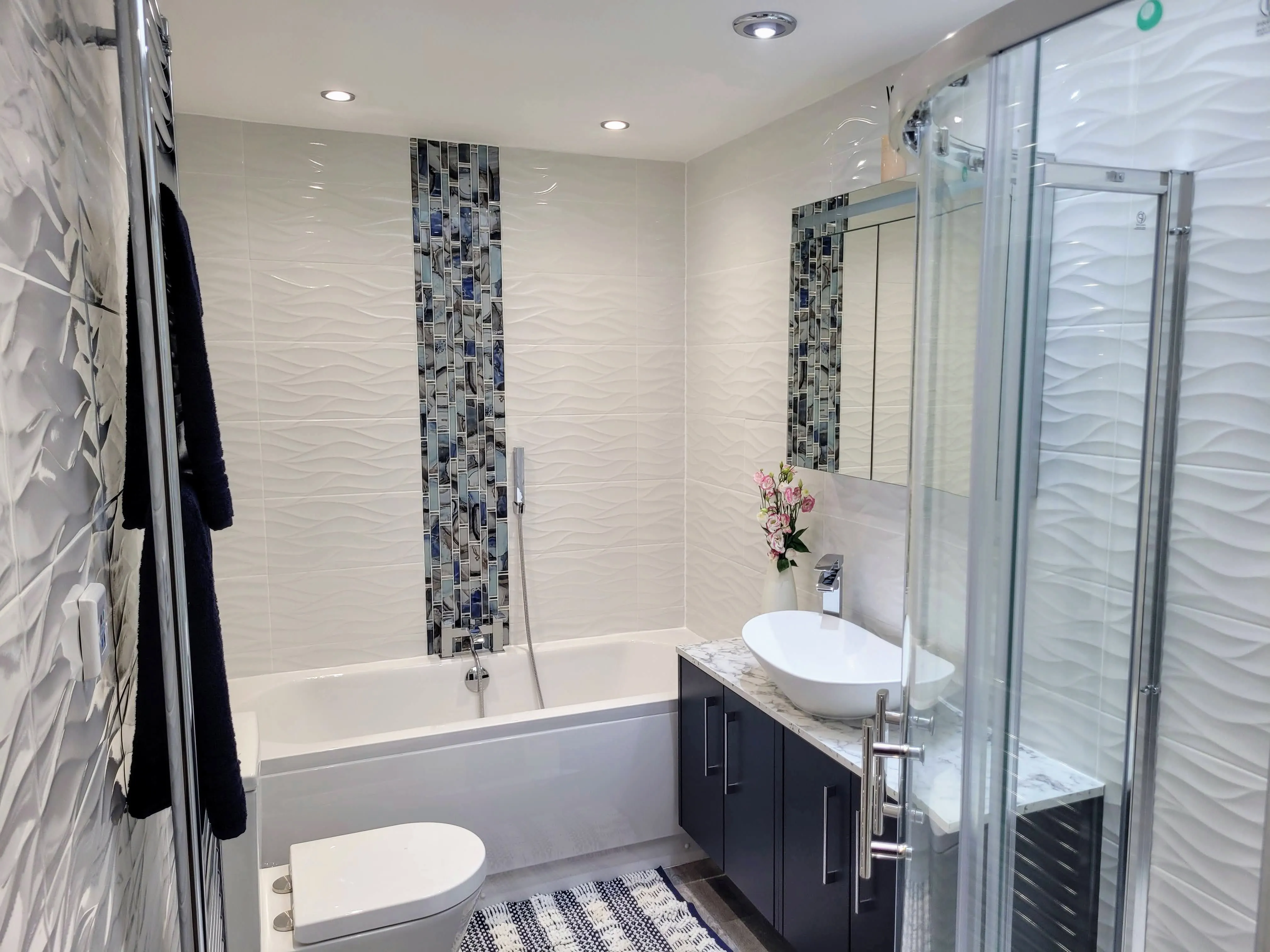 A bathroom with a sink, toilet, and shower.